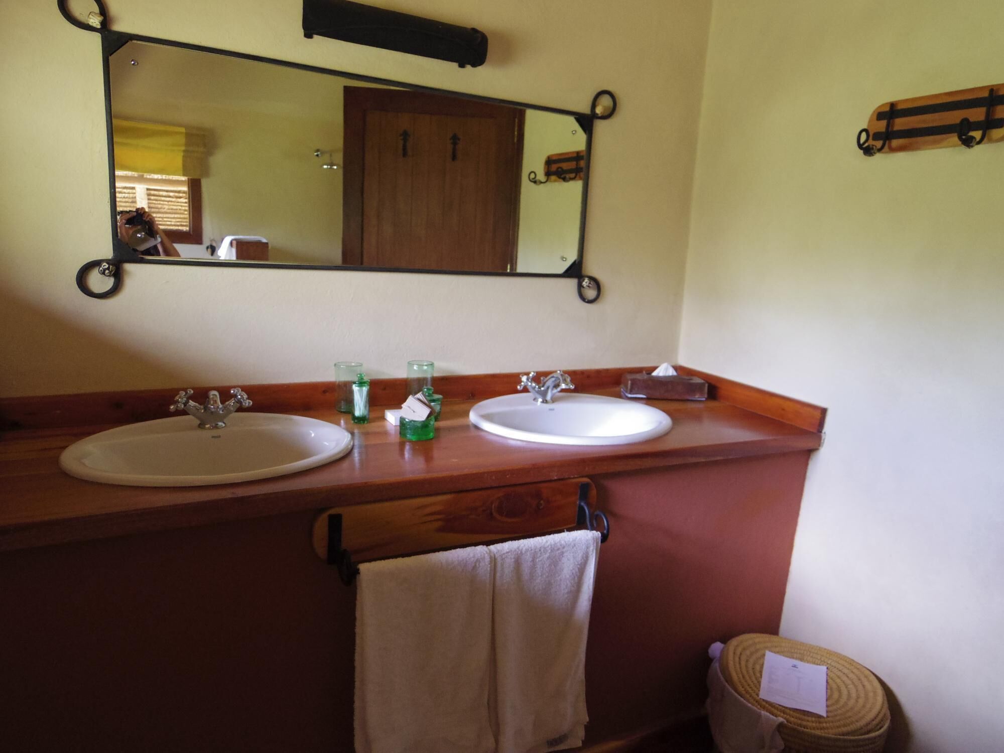 Un baño con dos lavamanos, un espejo y un toallero.