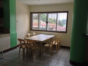 A room with a large window, a table, and six chairs. - Friendly's Guesthouse (Cebu City)