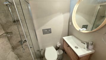 A bathroom with a shower, toilet, and sink.