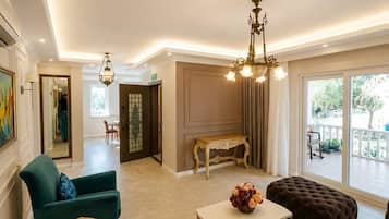 A spacious living room with a sofa set, a coffee table, and a chandelier.