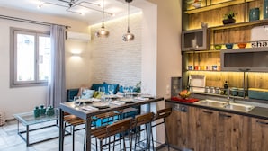 Una cocina moderna con comedor, que presenta una pared de ladrillo, iluminación colgante y armarios de madera.