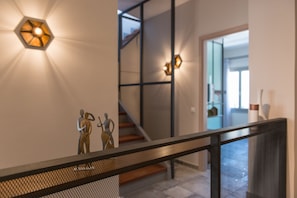 Stunning staircase with geometric light fixtures and abstract art, leading to a contemporary space with clean lines.