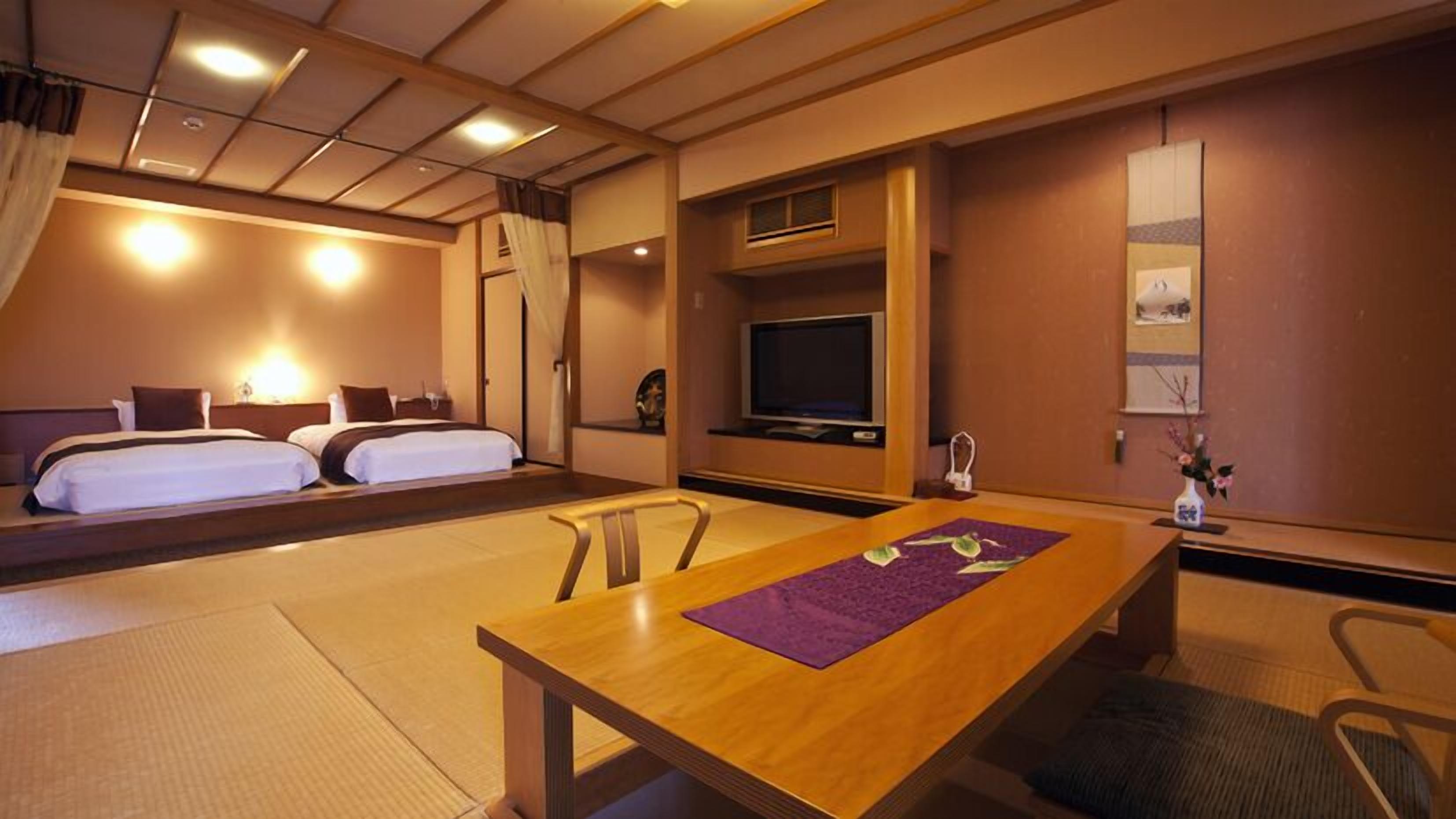 Ein Hotelzimmer mit Bett, Fernseher, Tisch und Stuhl.