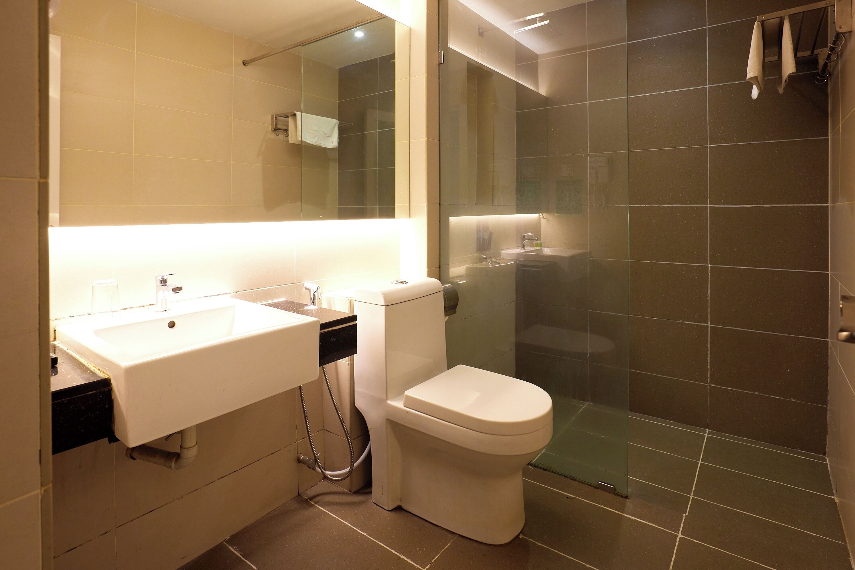 A modern bathroom with a sink, toilet, and glass-enclosed shower.