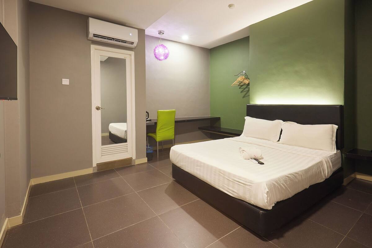 Une chambre d’hôtel équipée d’un lit, d’une chaise, d’un bureau et d’un appareil de climatisation.