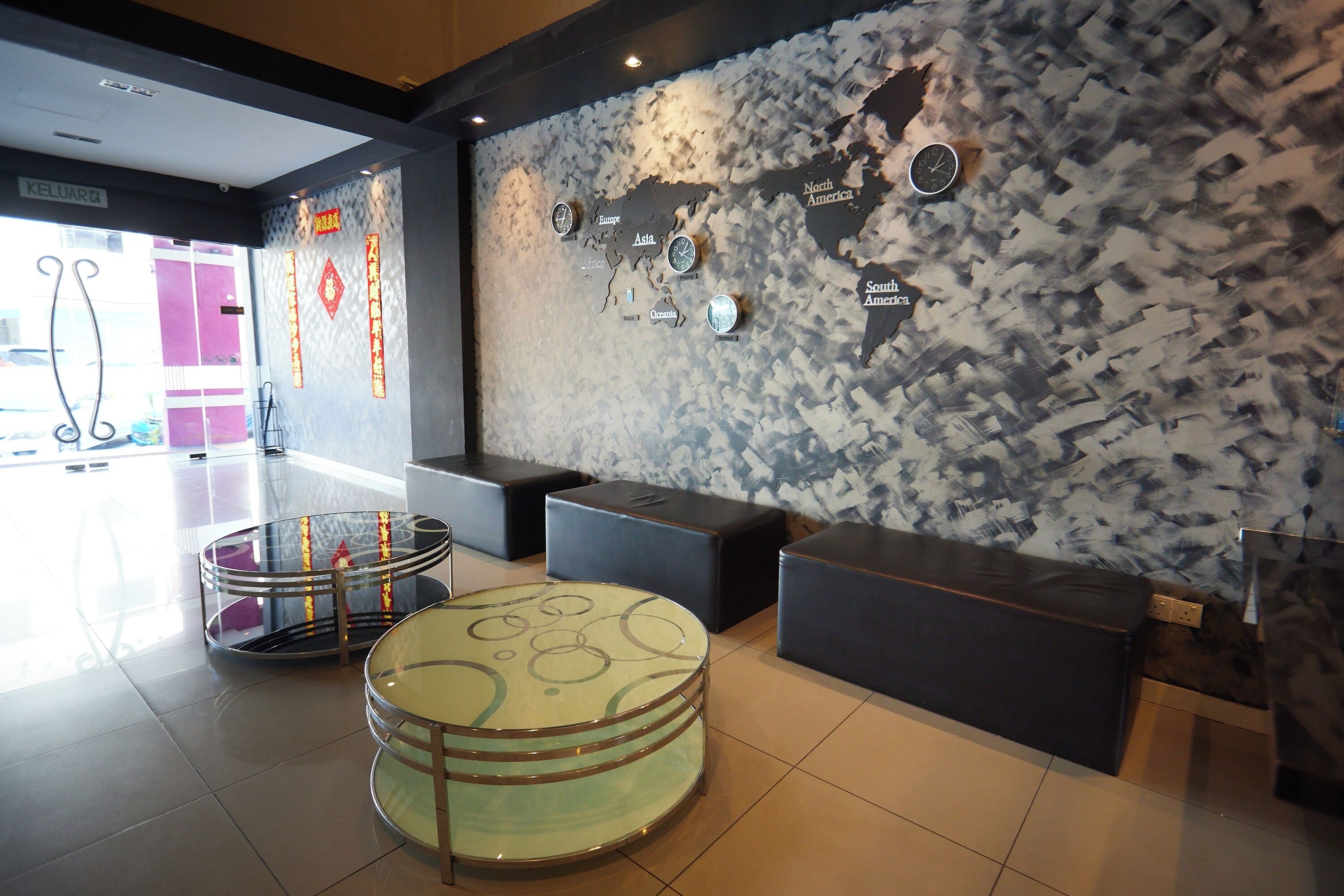 En moderne lobby med et verdenskort, siddepladser og et bord i glas.