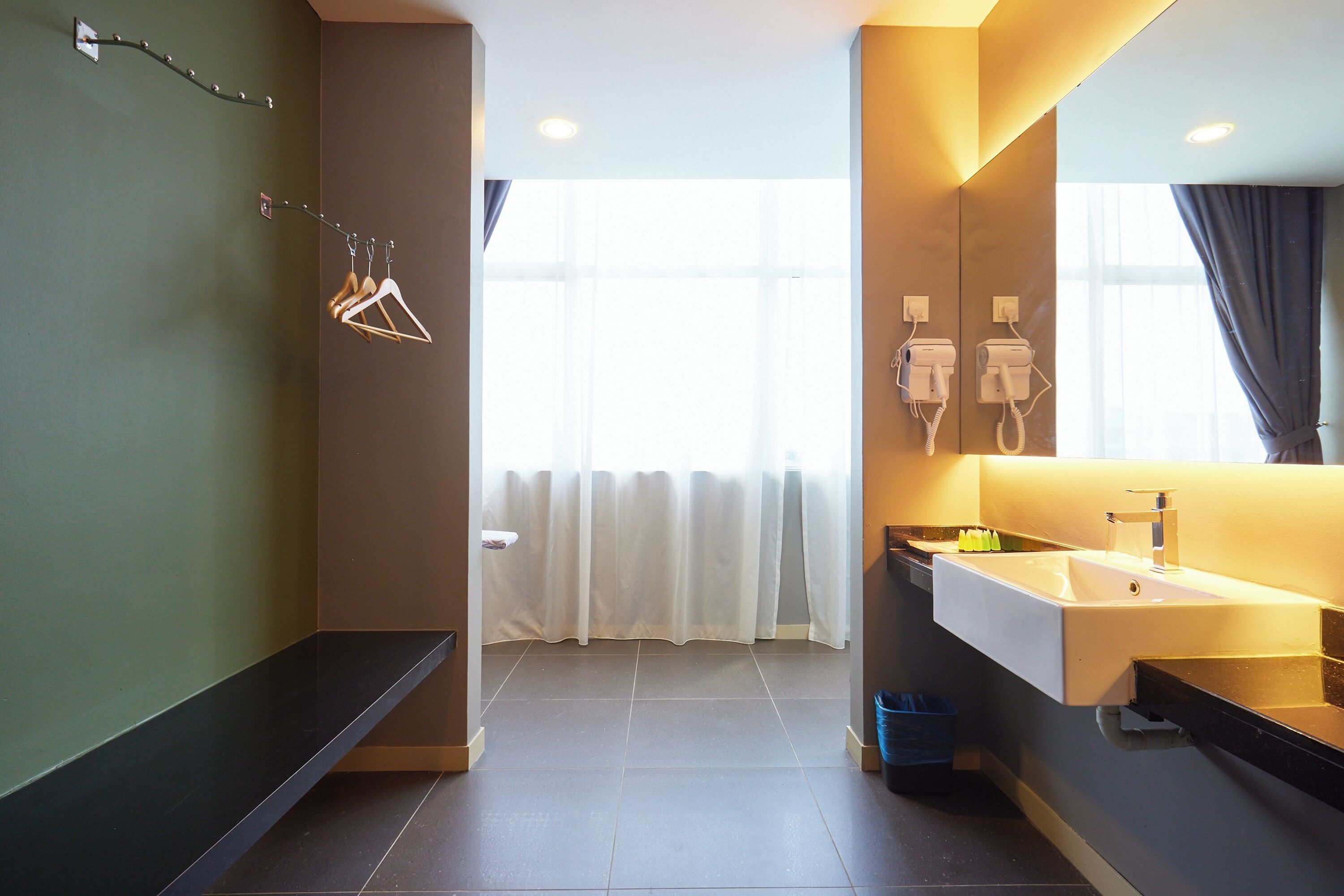 Un baño moderno con un lavamanos grande, espejo y toallero.
