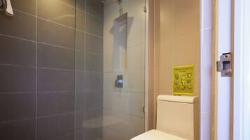 A modern bathroom with a glass-enclosed shower, a toilet, and a sign indicating not to flush the toilet.
