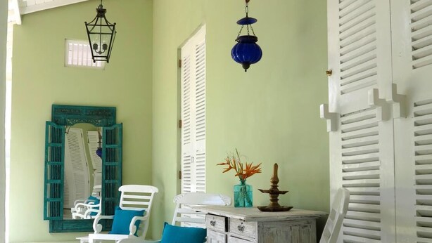 A room with white furniture, a tiled floor, and a green wall. - Bungalow Sud (Koggala)