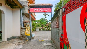L'ingresso di un hotel con un cartello che recita 'OYO MAHA BHARATA KUTA INN'.