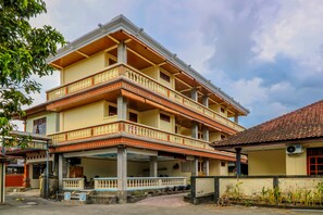 A multi-story building with balconies, a covered entrance, and a tiled roof. - Super OYO 1654 Maha Bharata Kuta Inn (Kuta)