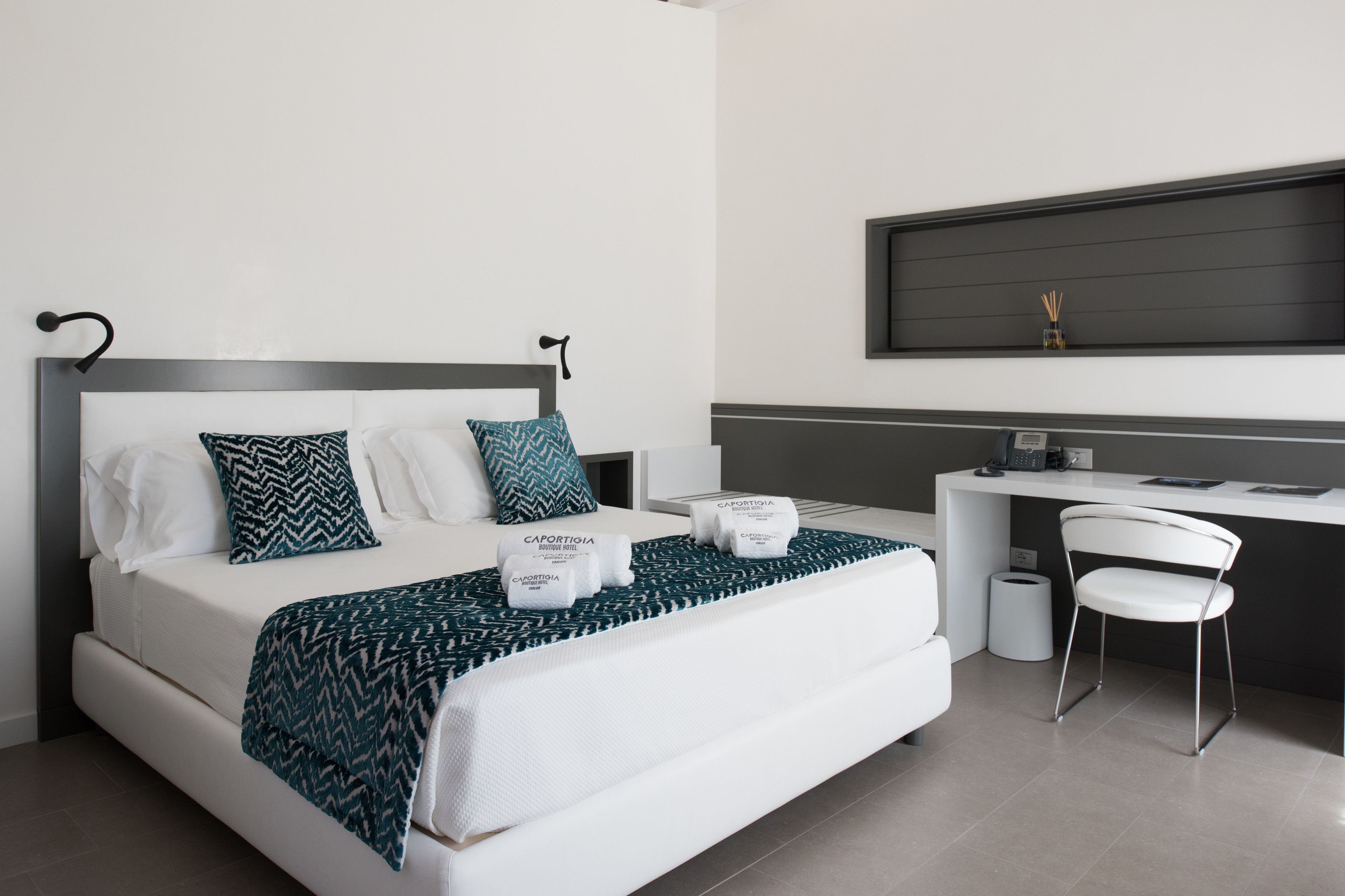 Ein modernes Hotelzimmer mit Bett, Schreibtisch und Stuhl.