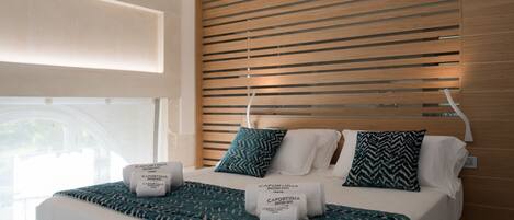 Une chambre d’hôtel avec un lit, une tête de lit en bois et deux oreillers.