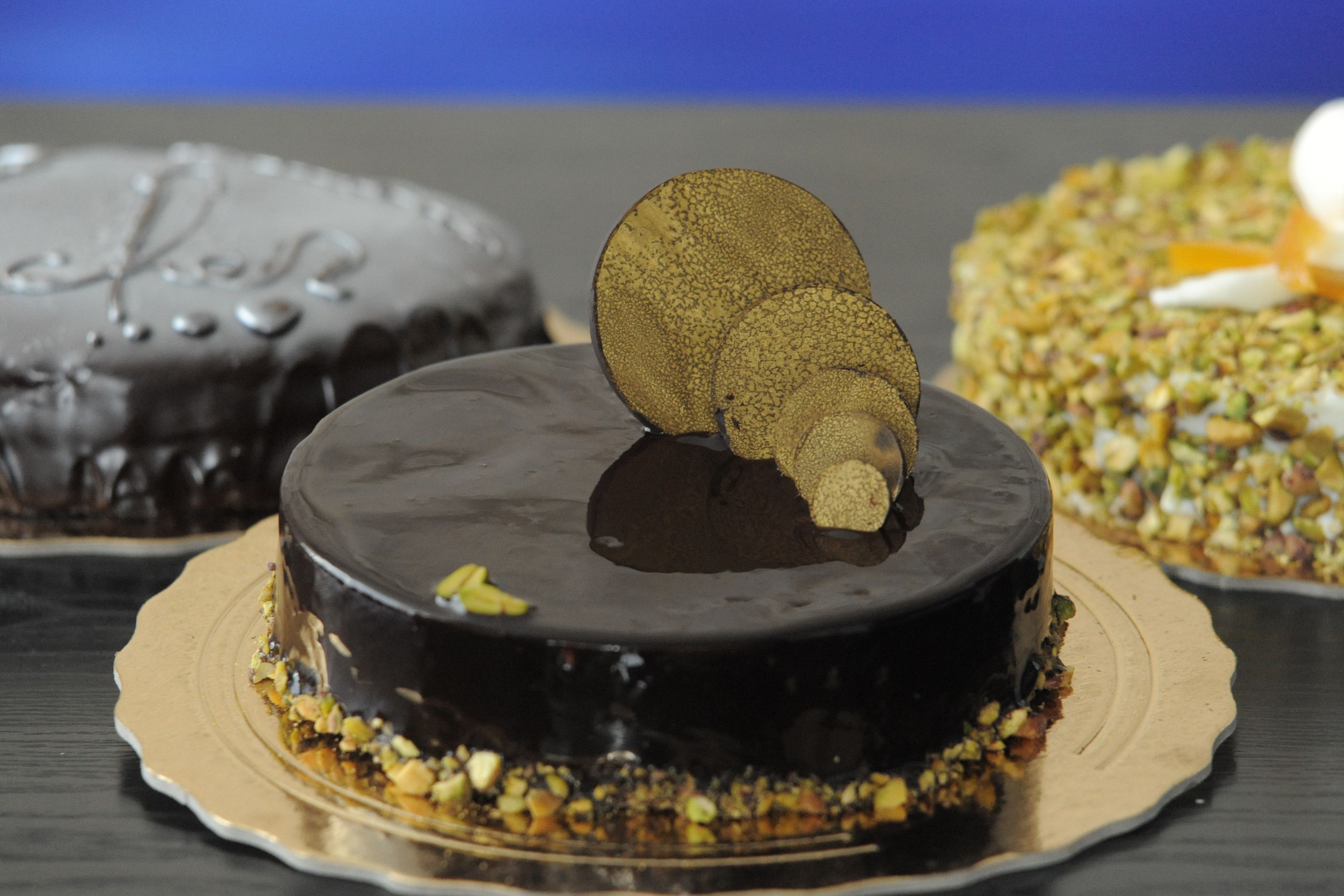 A chocolate cake with a chocolate glaze and a decorative chocolate piece on top.