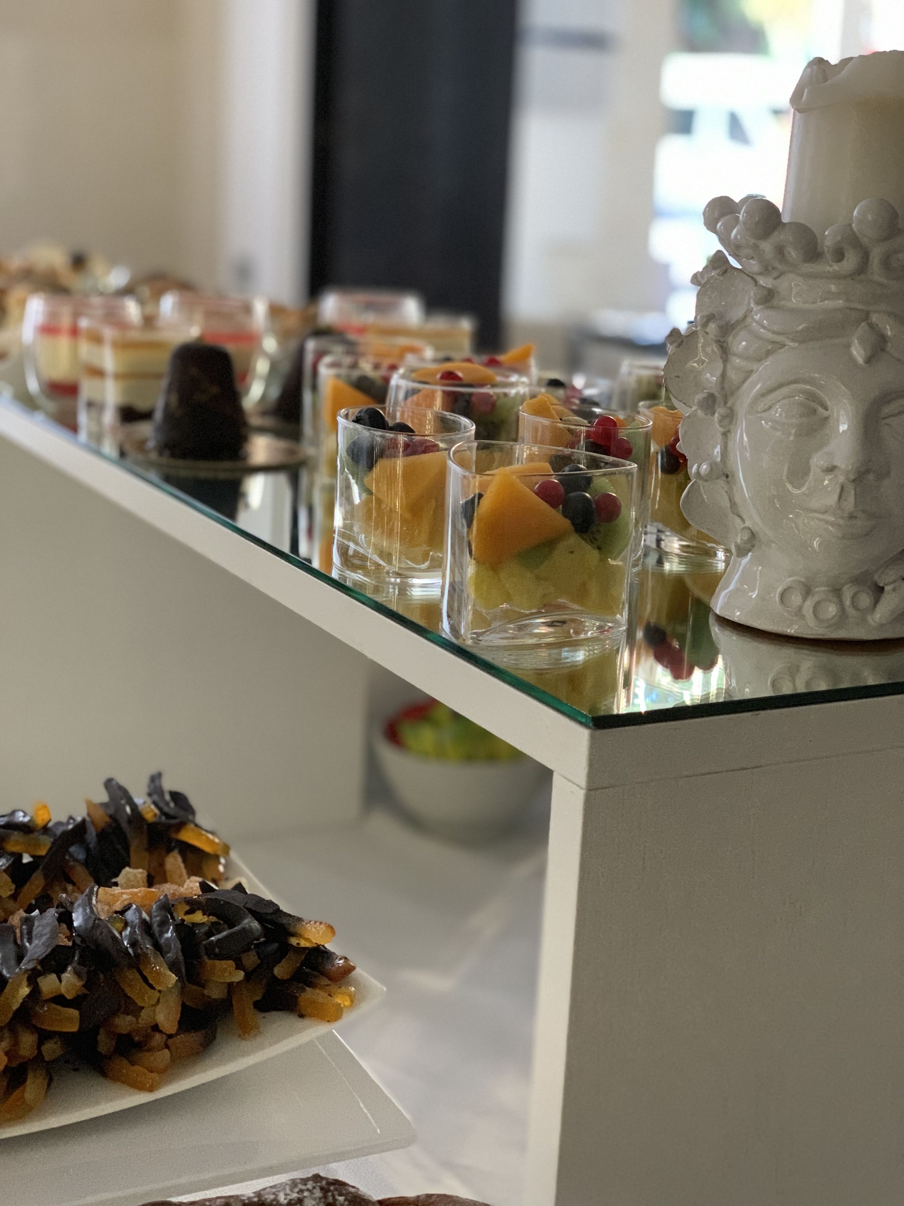 Un bufé con diversos postres y frutas.