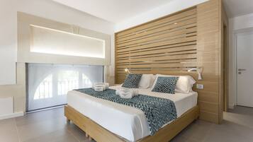 Un dormitorio moderno con una cama grande, cabecera de madera y estante empotrado sobre la cama.