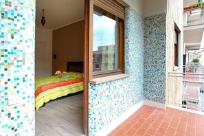 A room with a bed, a window, and a balcony with a tiled floor. - Oasi Verde a San Pietro (Rome)