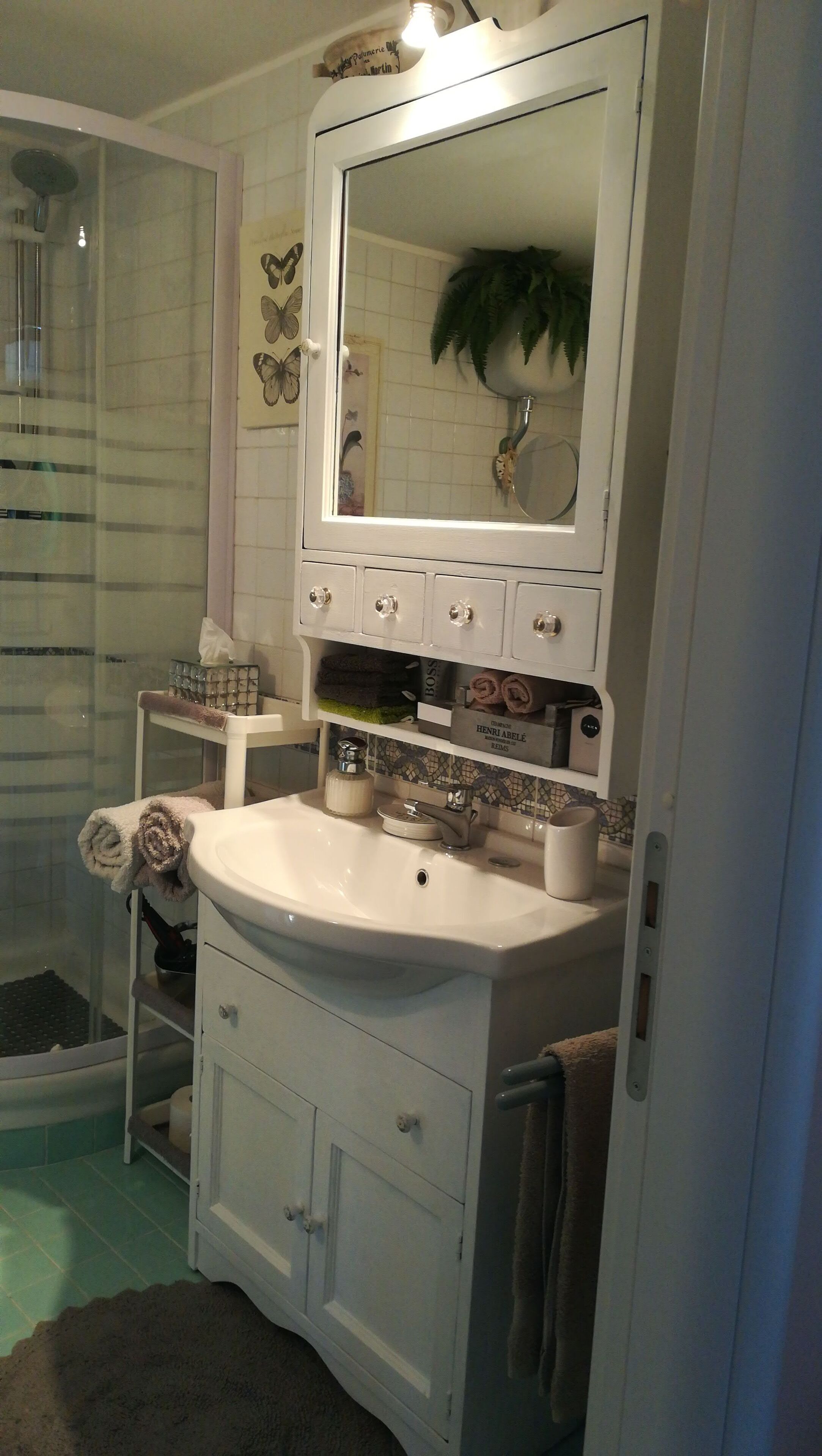 A bathroom with a white sink, a mirror, and a shower area.