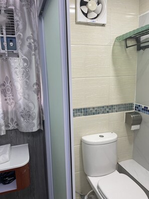 Une salle de bain comprenant des toilettes, un espace douche et un lavabo.