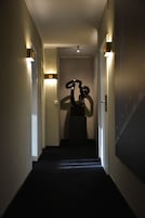 Un pasillo con un letrero con el número 33, una escultura e iluminación en la pared.