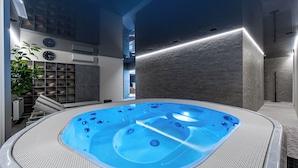 A modern indoor swimming pool with a clear view of the surrounding area, including a staircase and a plant. - Grand Baltic Dunes (Palanga)