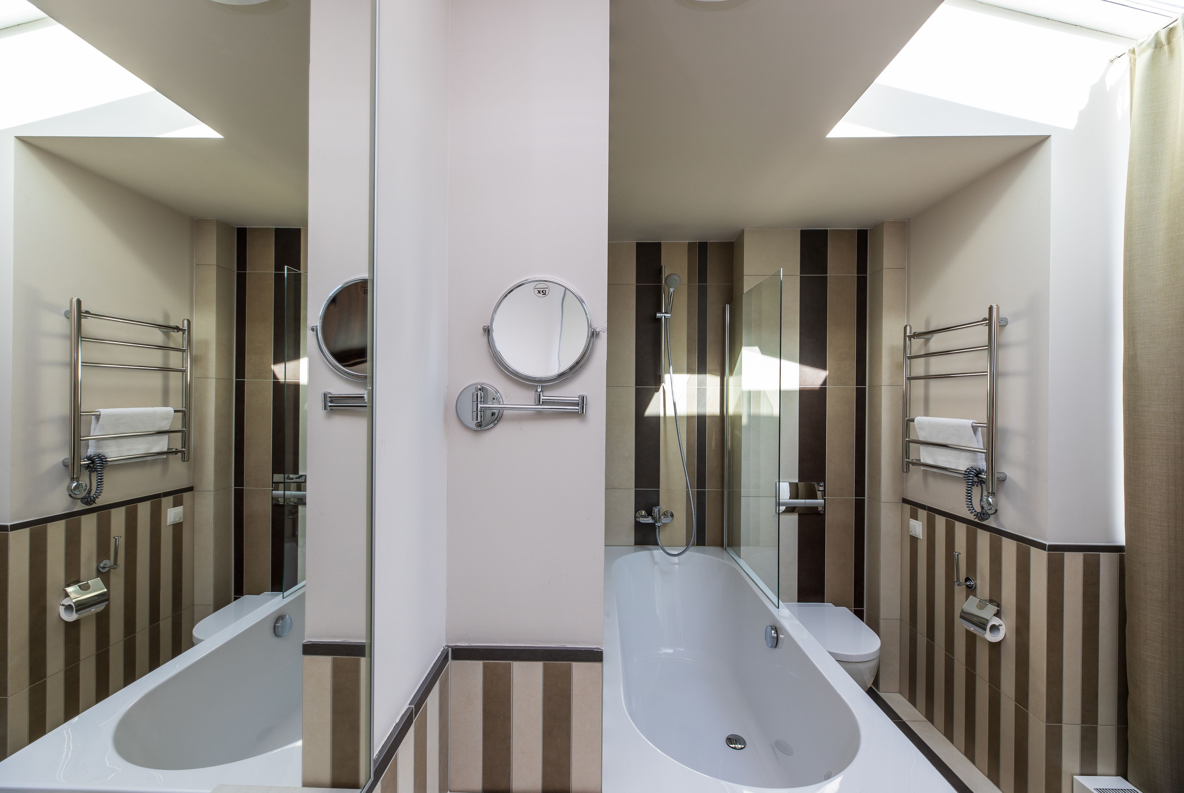 Ein modernes Badezimmer mit einer Badewanne, Toilette und einem großen Spiegel.