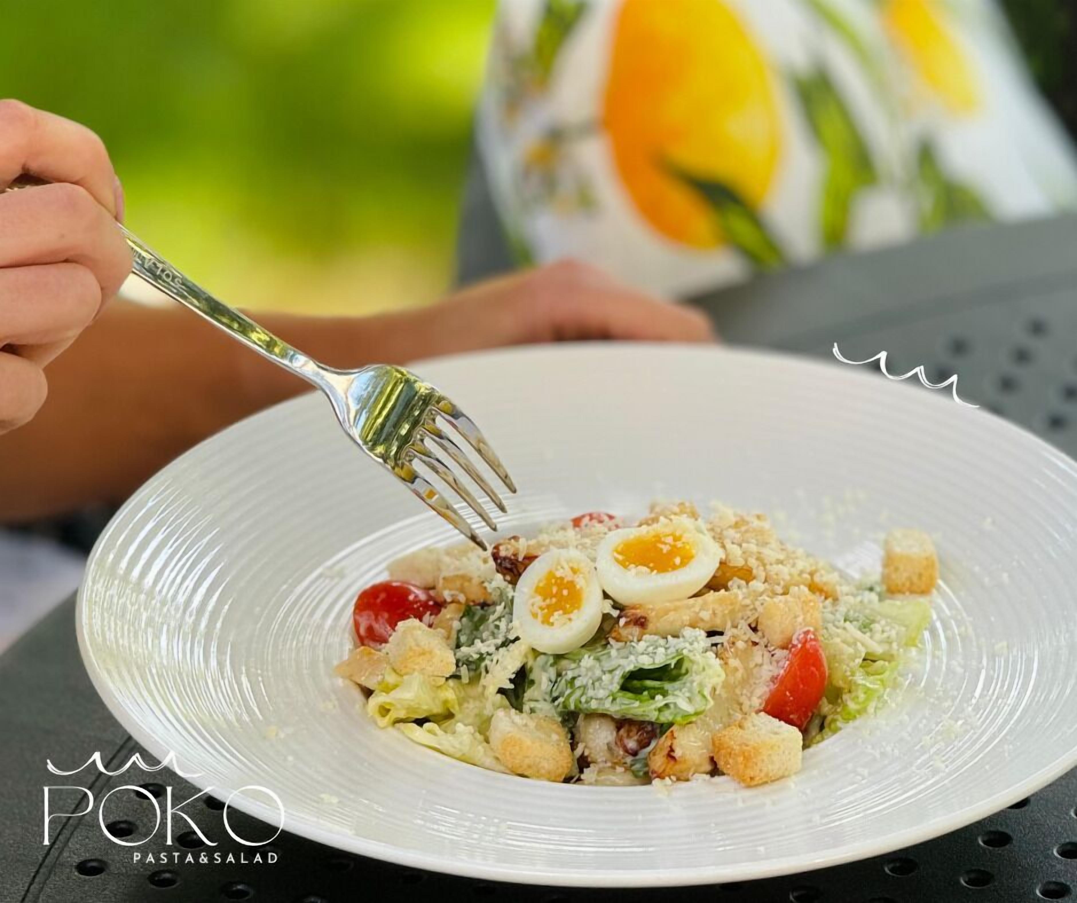 Ein Salat mit Croutons, Kirschtomaten und einem gekochten Ei.