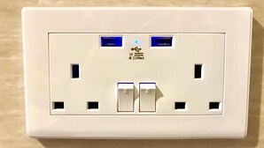 Eine weiße Steckdose mit zwei USB-Anschlüssen und zwei Schaltern.