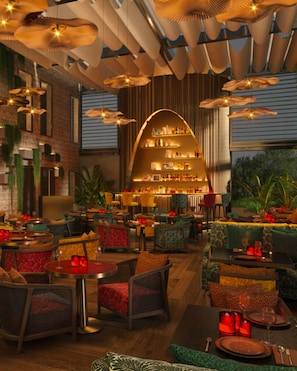 A restaurant with a central bar area, multiple seating options, and hanging pendant lights. - The View Rabat (Rabat)