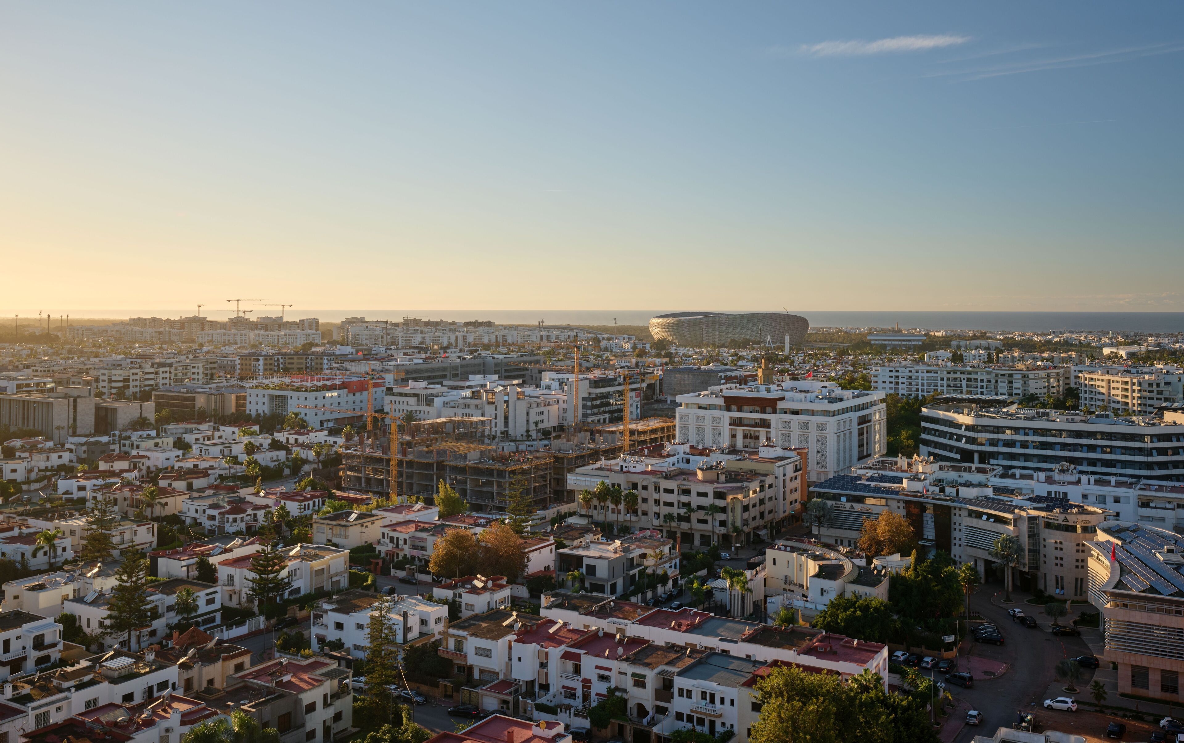 Un paisaje urbano que muestra un estadio, edificios residenciales y una combinación de arquitectura moderna y tradicional.