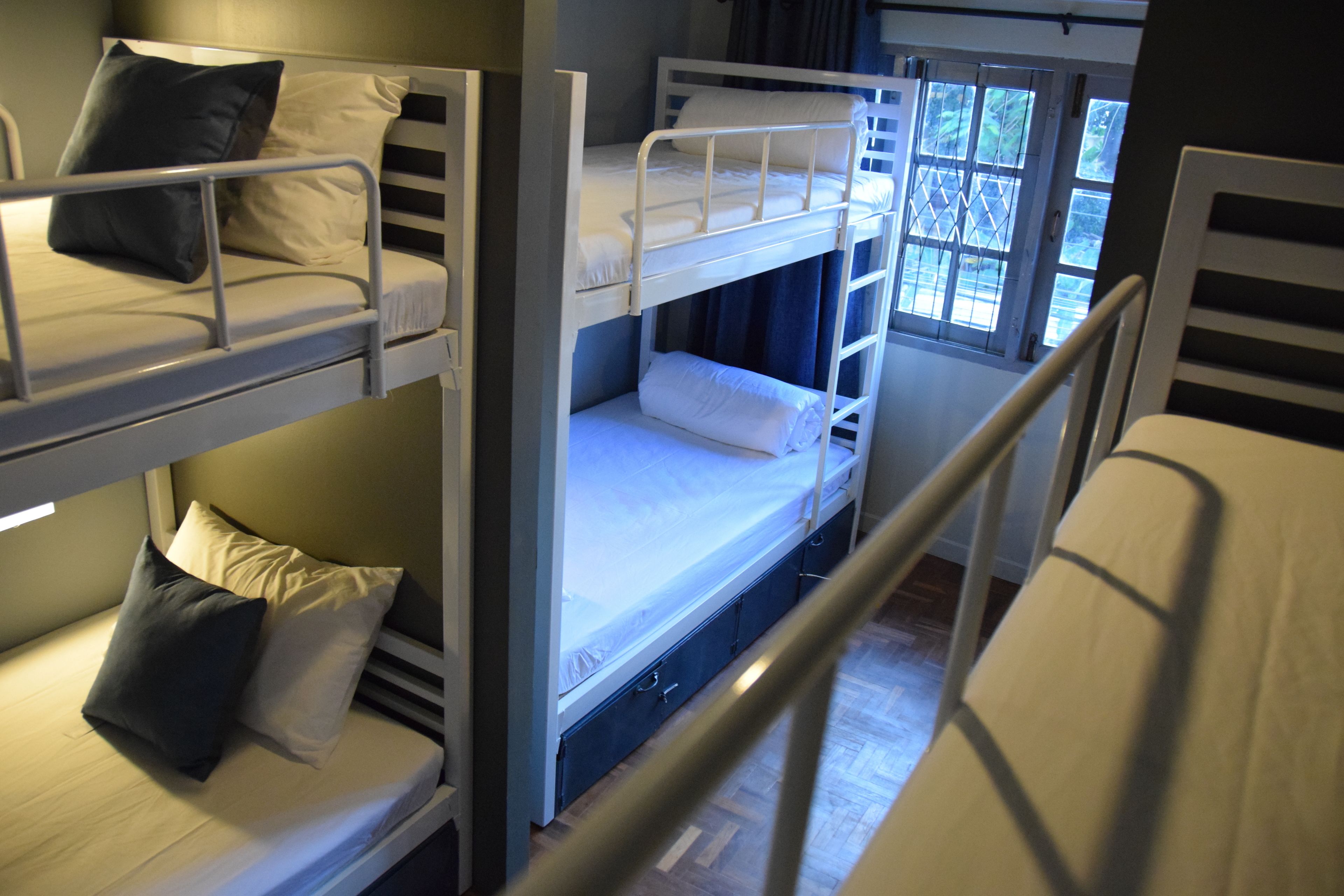 A bunk bed room with two beds, each with pillows and a mattress.