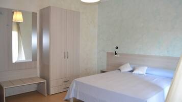 A bedroom with a bed, a wardrobe, a bench, and a nightstand.