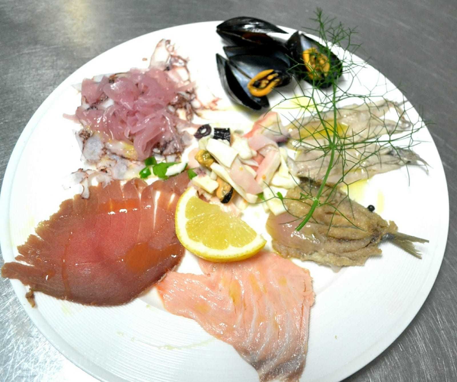 Ein Teller mit verschiedenen Meeresfrüchten, darunter Muscheln, Lachs und anderer Fisch.