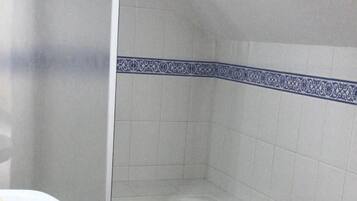 Un bagno con doccia, lavandino, bidet e WC.