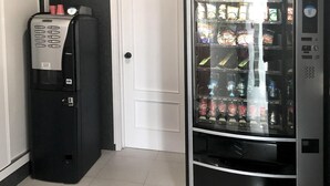 Un distributeur automatique équipé d’un appareil pour servir du Coca-Cola et d’un réfrigérateur contenant diverses boissons.