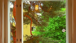A table with a tray of items, a window with a view of trees, and a door with a handle. - Wonderful Helsinki Apartment (Helsinki)