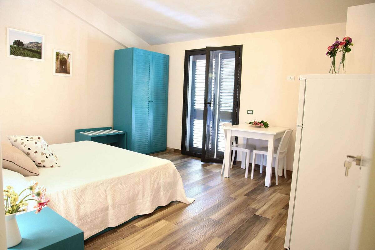 Ein Schlafzimmer mit Bett, Schreibtisch, Stuhl und Kleiderschrank.