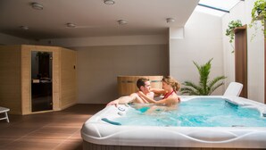 Un moderno jacuzzi interior con paneles de madera y vistas a un mueble de madera.