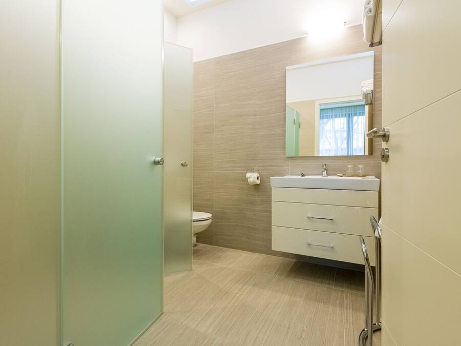 Un baño moderno con inodoro, lavamanos y espejo.