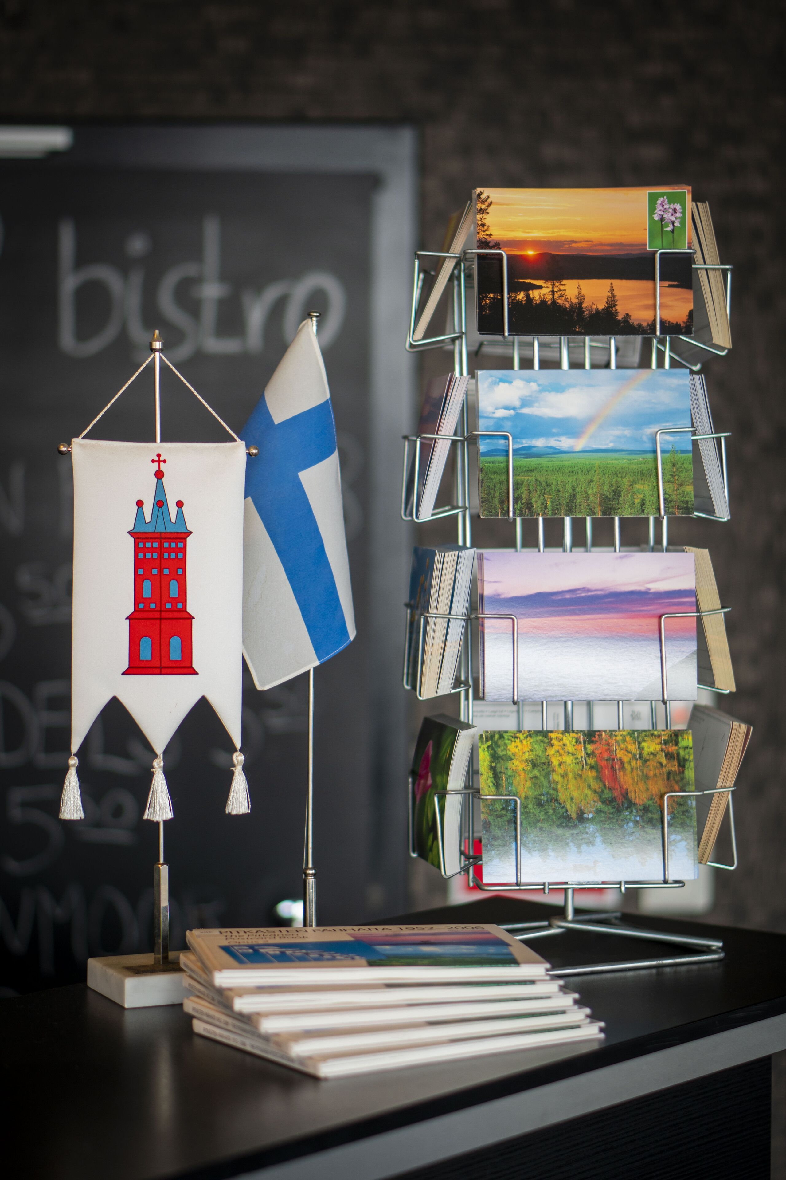 A stack of books, a flag, and a small model of a building.