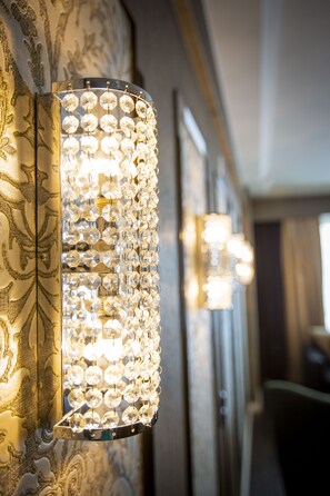 Luminária de parede com múltiplos detalhes de cristal transparente.