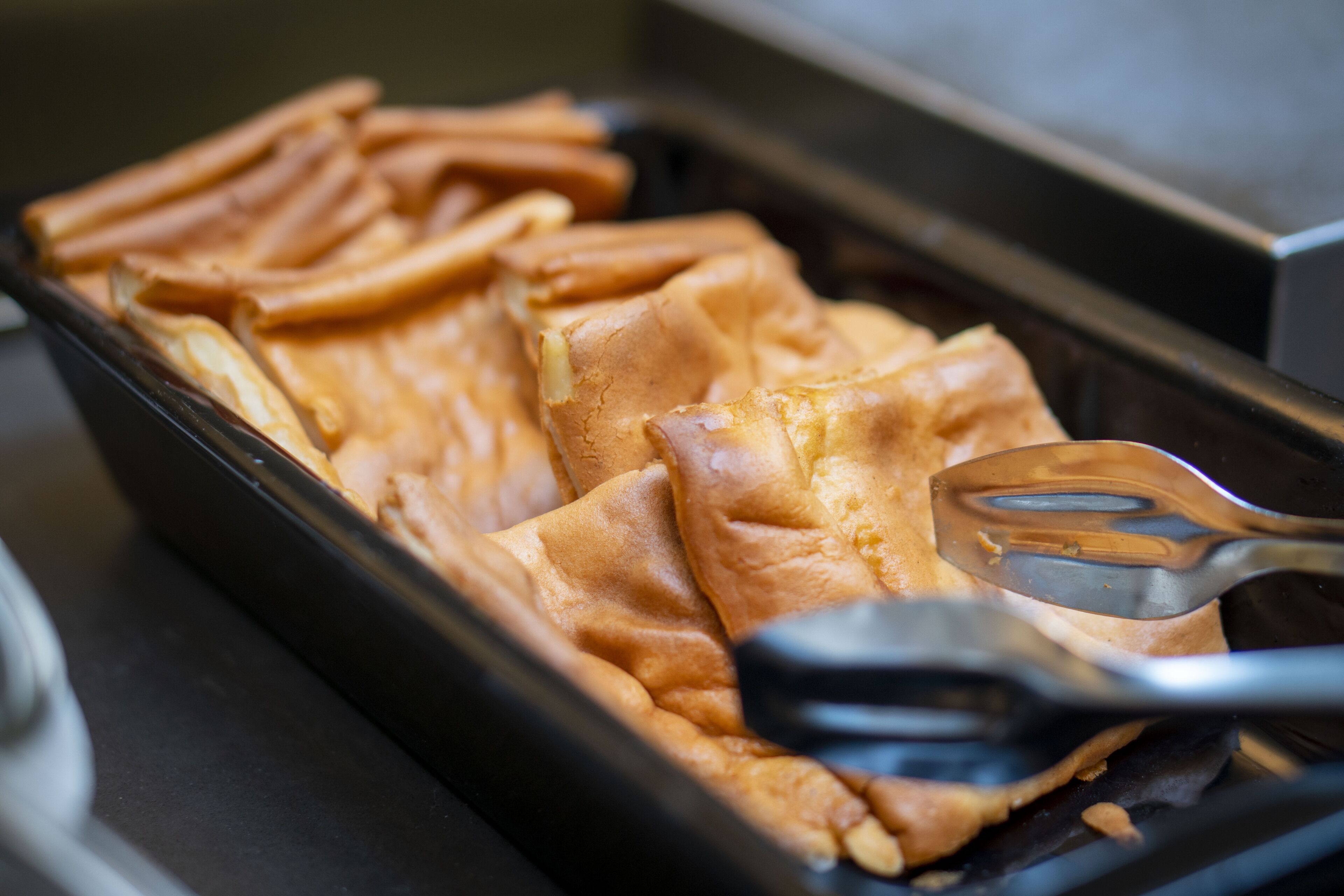 A tray of waffles with a spatula.