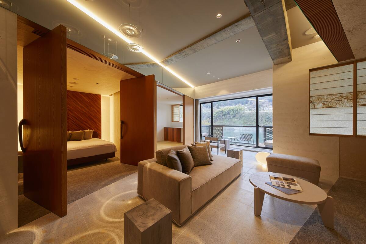 A modern living room with a sofa, coffee table, and a wooden partition.