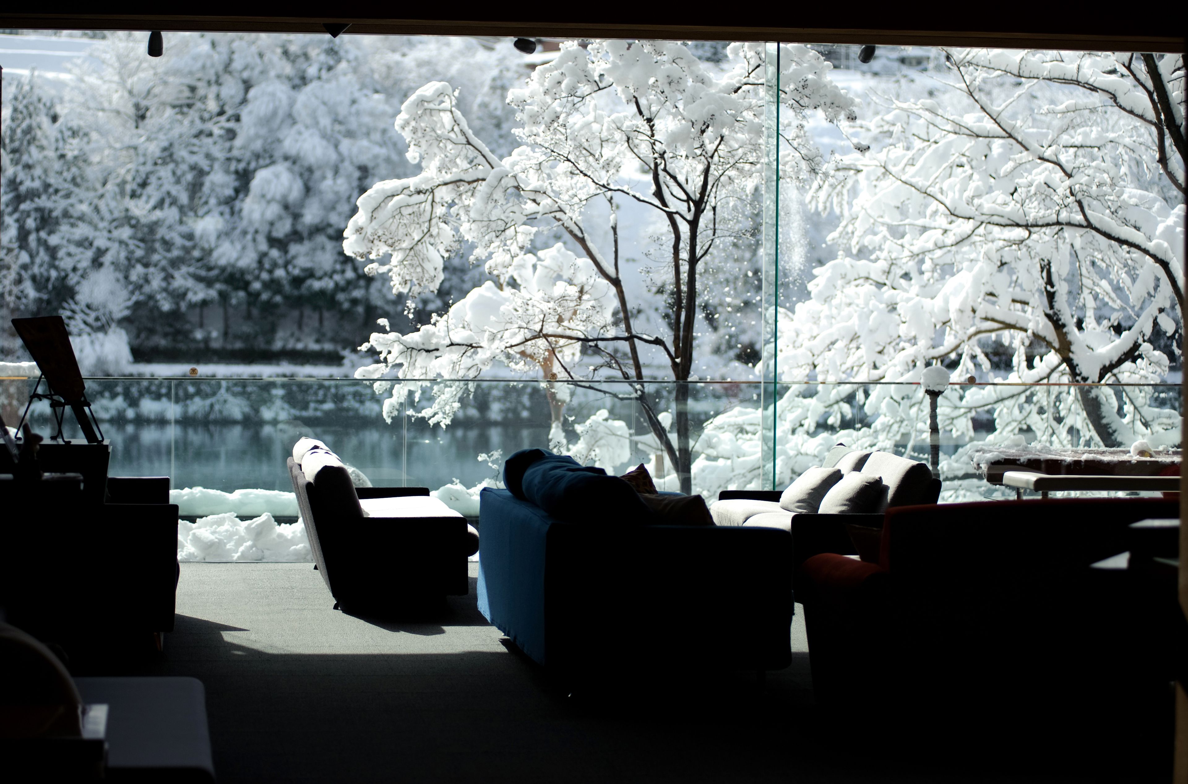 A room with a large window overlooking a snowy landscape.