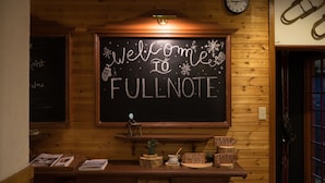 Un intérieur en bois avec un panneau noir sur lequel on peut lire : « Bienvenue chez Fullnote ».