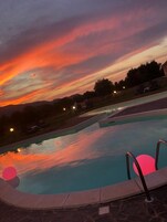 Una piscina al aire libre de temporada, sombrillas