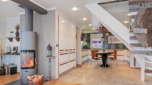 A modern kitchen with white cabinets, a central island, and a built-in stove. - RIBO Apartment Katterjokk (Riksgränsen)