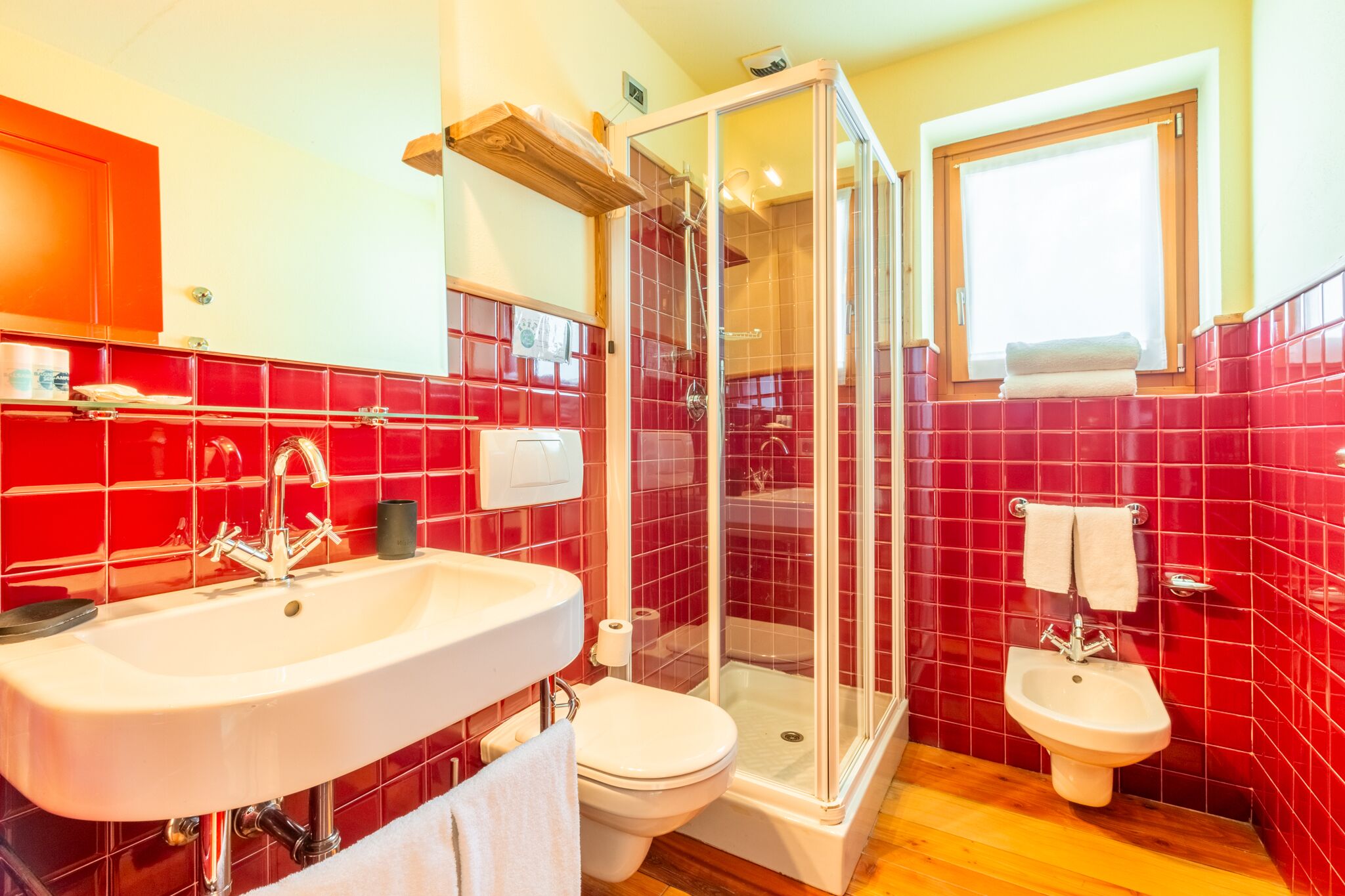Une salle de bain équipée d’une douche, de toilettes et d’un bidet, tous dotés de robinetterie chromée.