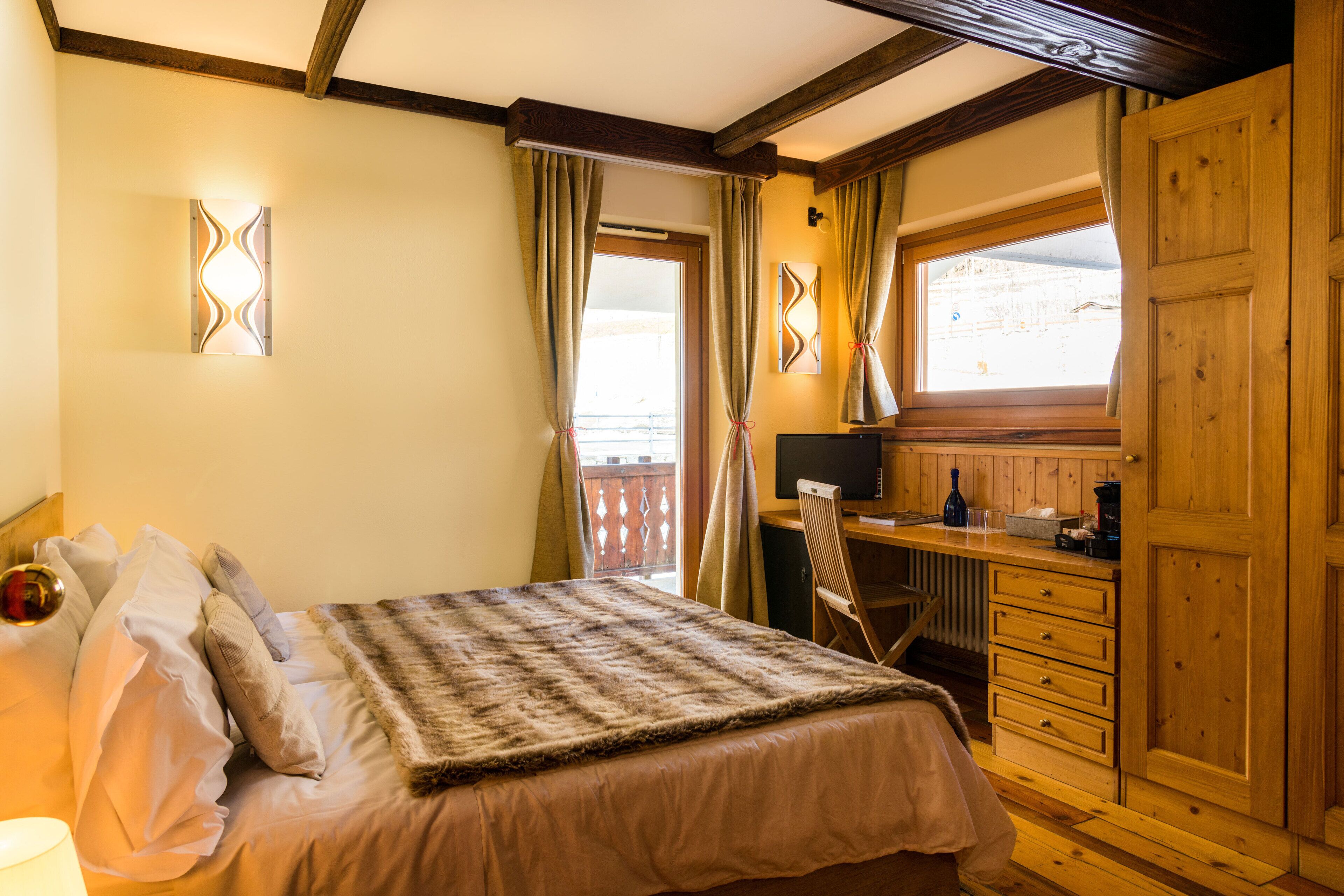 Un dormitorio con cama, escritorio y armario.