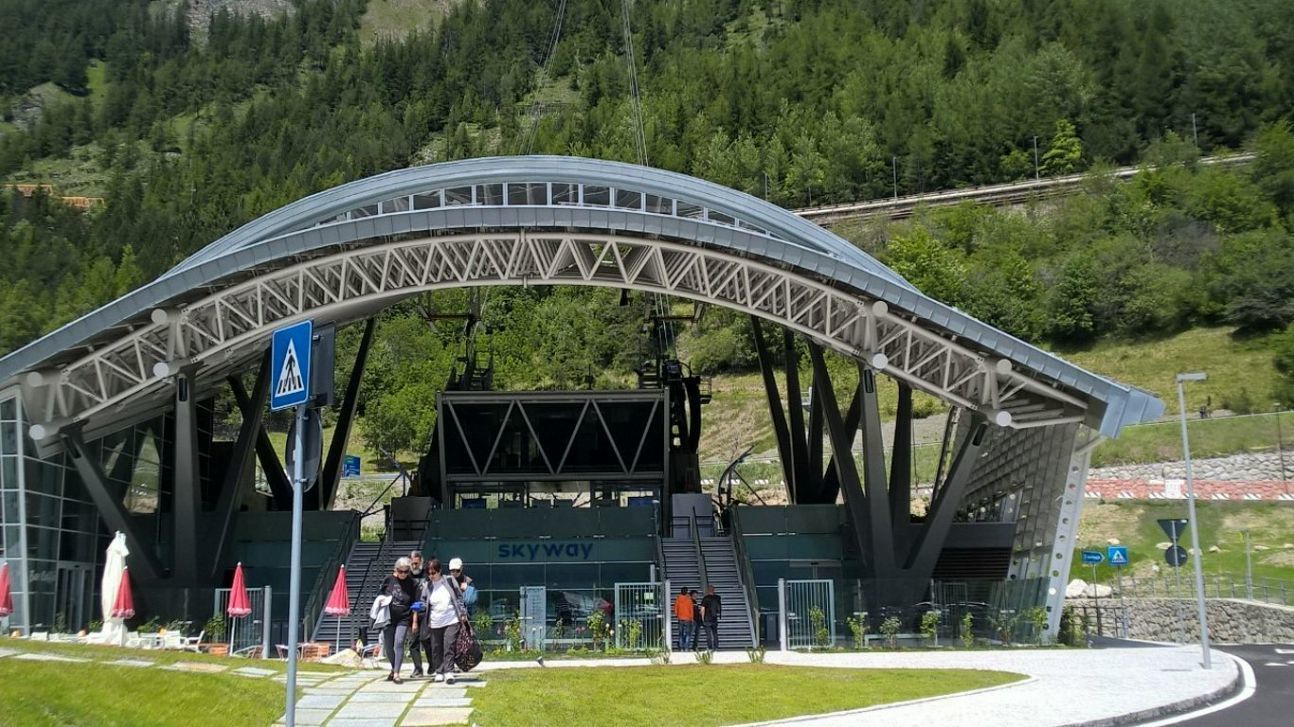 A modern architectural structure with a large arched roof and a sign that reads "SKYWAY".